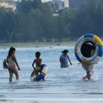 suara-jakarta-Para-Pengunjung-sedang-asik-mandi-pantai-di-tengah-tengah-aksi-bersih-pantai