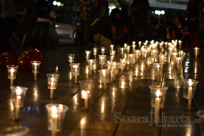 Aji Jakarta menyalahkan ratusan lilin di Bundaran HI sebagai bentuk duka cita atas kekerasan terhadap jurnalis di Jogja. (Foto: Fajrul Islam/SuaraJakarta)
